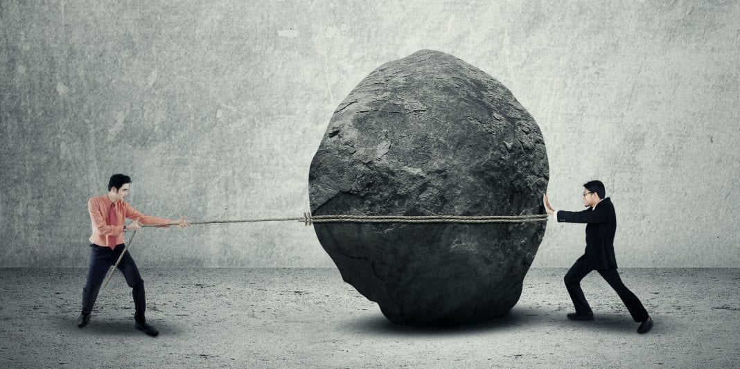business people moving large stone Public Relations vs SEO