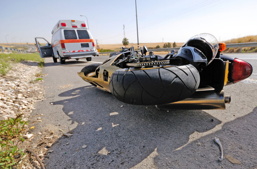 dreamstime_l_5052657 Emergency respondents arrive to scene of accident where a crashed motorcycle is on the ground