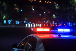 police car depicted arriving at late night car crash