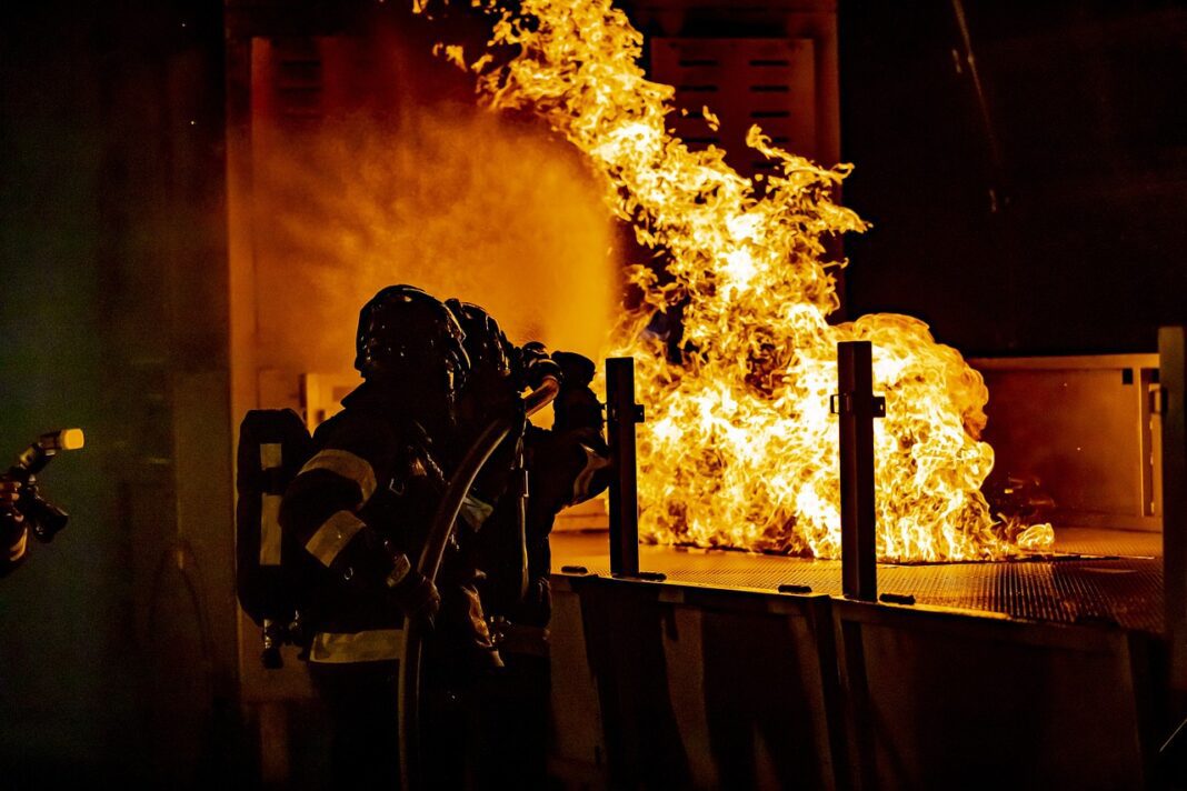 firefighters firefighters attempting to put out large Apartment fire